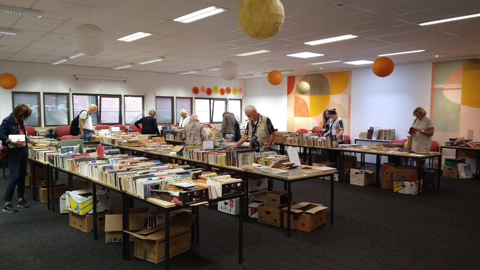 Tafels vol tweedehands boeken in de speelzaal