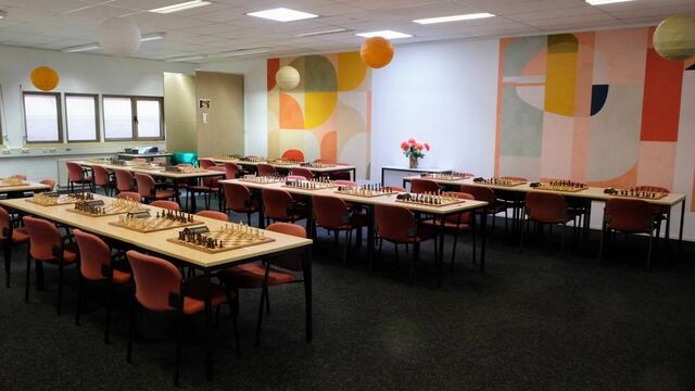 Speelzaal met schaakborden en een kleurrijke wandschildering