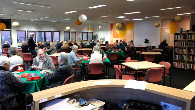 Zicht vanaf de bar over de volle speelzaal