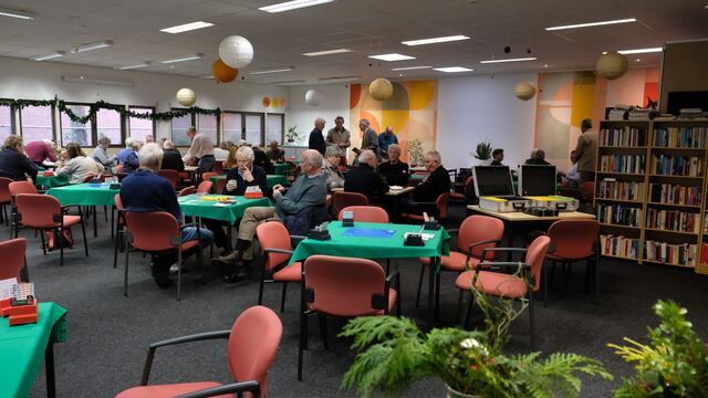 Bezoekers aan de speeltafels in de versierde zaal